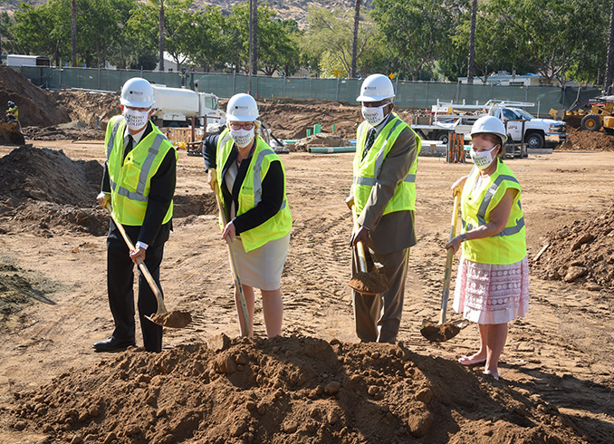 College president, chancellor and board of trustees members hold shovels and pose for a photo at groundbreaking