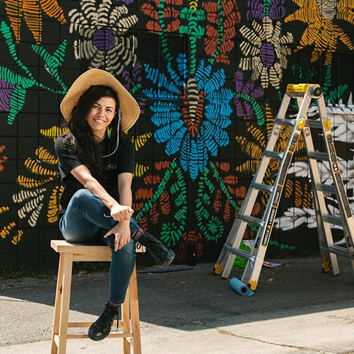 Artist Rosy Cortez in front of the El Trigo mural in Riverside, CA