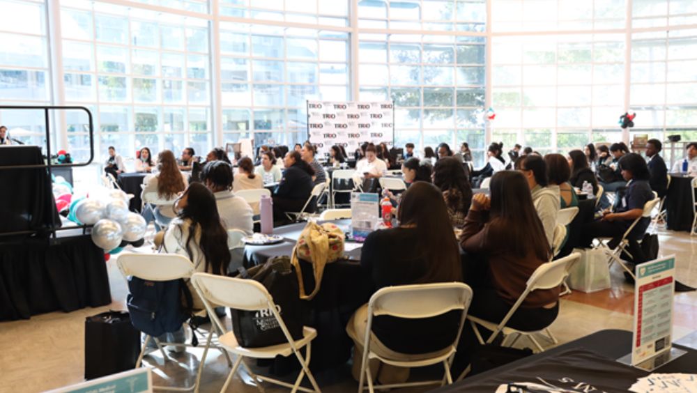 Students are seated at tables in Student Academic Services, listening to presentations