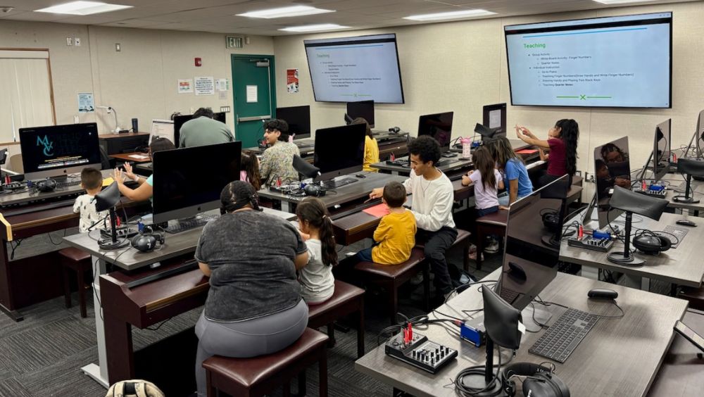 Music club members teach young learners keyboard one-on-one