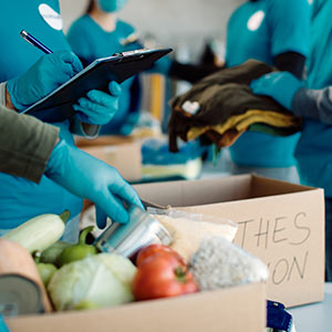 Volunteers pack boxes of food and clothing