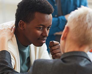 A student smiles at a counselor offering support